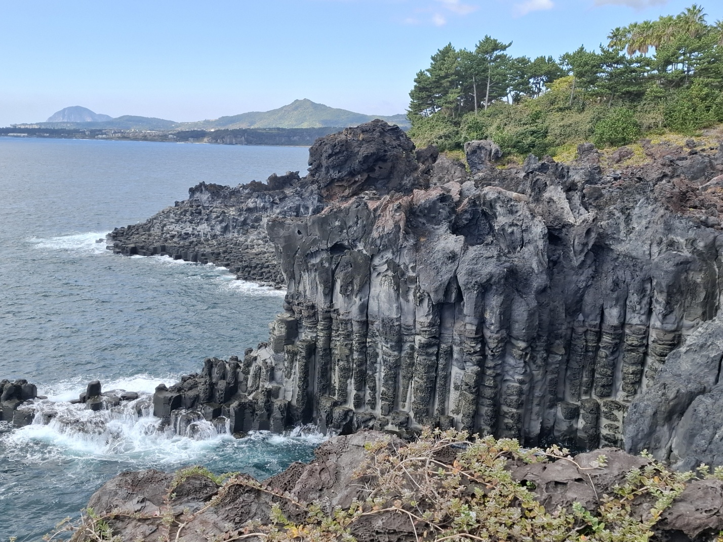 Jusangjeolli Cliff hexagonal basalt columns rising from ocean in South Jeju